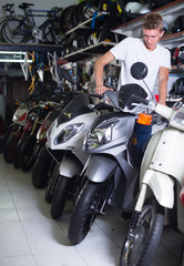 Fototapeta na wymiar calm man motorcyclist choosing the bike in the shop