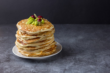 Homemade thin pancakes with berries on a plate. Food for the carnival.