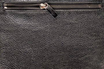 background texture black leather. Pocket of the bag with a lock, open half-lock zipper top, close up