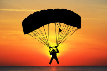 Silhouette Skydiver in sky on  sunrise