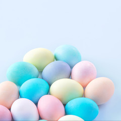 Colorful Easter eggs dyed by colored water isolated on a pale blue background, design concept of Easter holiday activity, close up, copy space.