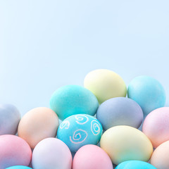 Colorful Easter eggs dyed by colored water isolated on a pale blue background, design concept of Easter holiday activity, close up, copy space.