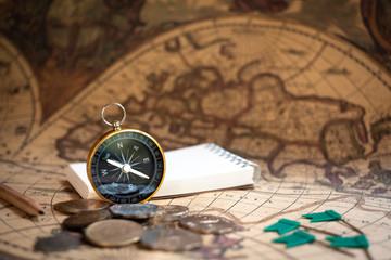 Fototapeta na wymiar Compass on old vintage brown map background, journey planning concept
