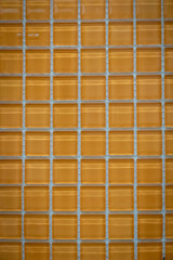 Yellow ceramic mosaic on the wall as background