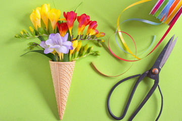 Freesias flowers in ice cream waffles and scissors