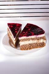 Two cakes with curd filling and berry topping on a white plate