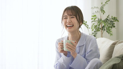 パジャマ姿でマグカップを持つ女性