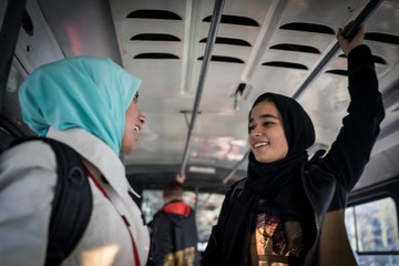 Mother and daughter riding public transport in city