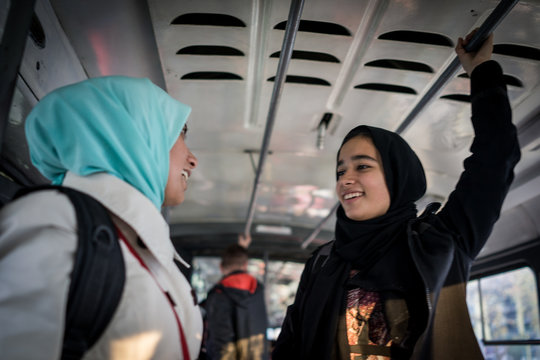 Mother and daughter riding public transport in city