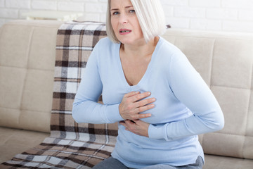 Portrait of middle aged woman having heart attack
