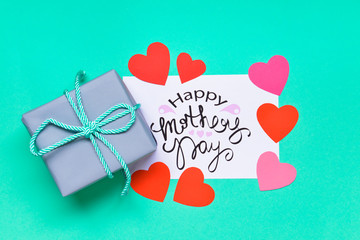 Beautiful greeting card and gift for Mother's Day on color background