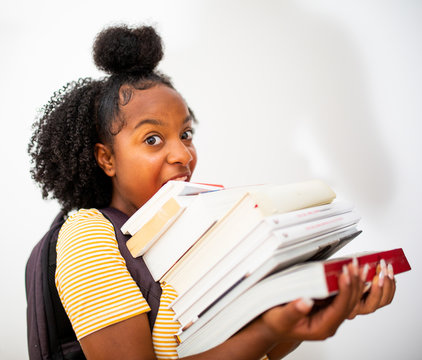 black teenage girl student holding many books by white background