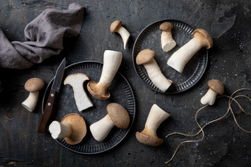 Fresh raw mushrooms, king oyster or eringi on vintage tray with knife