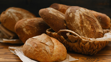 Assortment of baked bread on wooden table background. Bread background, top view of white, black and rye loaves. Healthy food. 