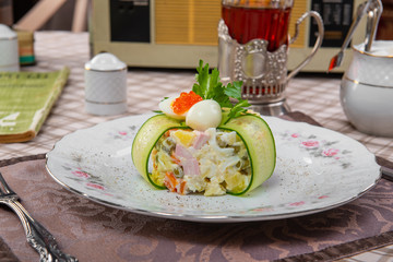 Olivier salad on a tablecloth in a brown cage
