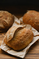 Assortment of baked bread on wooden table background. Bread background, top view of white, black and rye loaves. Healthy food. 