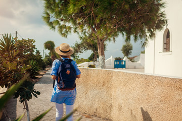 Santorini traveler exploring discovering greek architecture in Akrotiri. Woman backpacker walking...