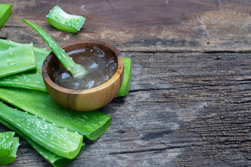 Fresh aloe vera stem slices and gel on wooden table, skin therapy concept