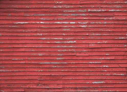 Close up on Red Barn faded red wood siding. 
