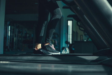 foot Fitness girl running on track treadmill, exercise, workout at fitness gym.