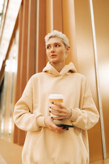 Real young  woman with tea and cellphone