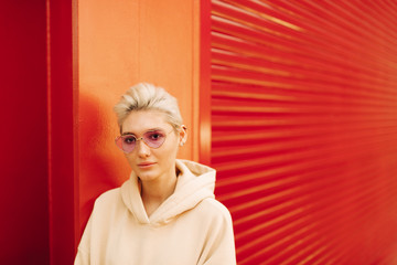 Blond young woman with pink sunglasses