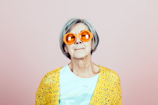 happy elderly grandma portrait with orange sunglasses - forever young lifestyles