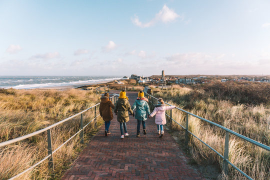 Young kids walking together towards the city and the sea, during their family vacation in the dunes of Domburg, The Netherlands