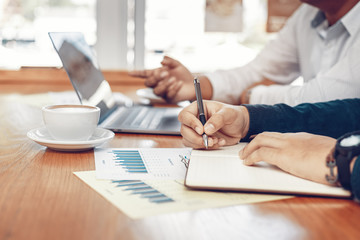 Businessman working and meeting together in the office. Hand writing note and calculate data.