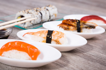 four kinds Nigirisushi on oval saucers and Uramaki