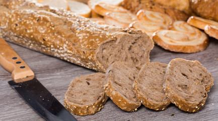 slices of wheaten bread and knife on wooden surface