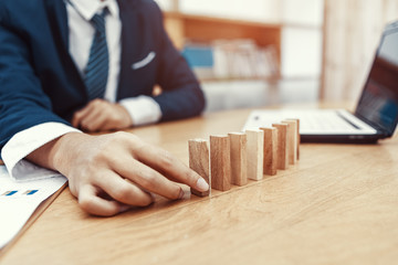 Male hand stacking wooden blocks. Business development and growth concept