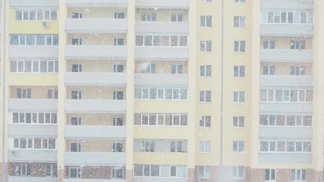 snowfall in front of a modern new brick apartment building View from the window