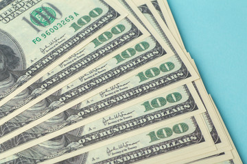 American dollars on the table. One hundred (100) dollars laid out on a blue background. American...