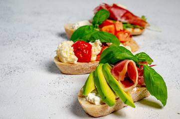Assorted bruschetta with various toppings.Appetizing bruschetta.Variety of small sandwiches.Mix bruschetta