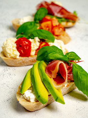 Assorted bruschetta with various toppings.Appetizing bruschetta.Variety of small sandwiches.Mix bruschetta