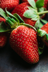 Ripe and juicy strawberry on the dark rustic background. Selective focus. Shallow depth of field.