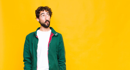 young crazy bearded man with a worried, confused, clueless expression, looking up to copy space,...