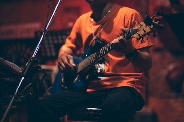 Obraz premium man hand playing guitar acoustic and singing on the stage at night.