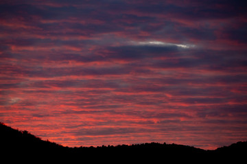 Fantastic gradient sundown cloudscape, mountain silhouette on the bottom of image