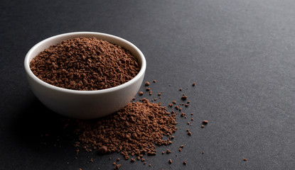 Pile of cocoa powder on black background