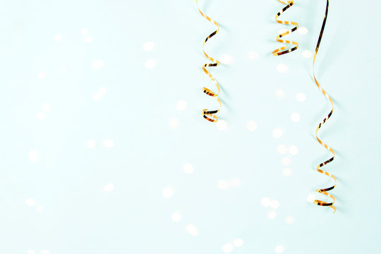 Gold serpentine isolated on shiny bokeh lights on festive  background. Holiday decoration for parties, birthday, greeting card with copy space