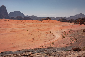 Panoramic view of rocky mountains and red sand in the Jordanian desert of Wadi Rum.