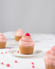 Cupcake with pink buttercream and pomegranate seeds