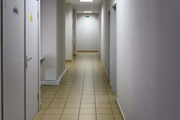 Photo of a corridor in a building with white walls and doors to the toilet