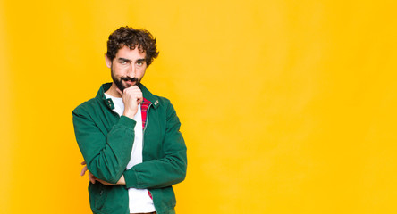 young crazy bearded man looking serious, confused, uncertain and thoughtful, doubting among options...
