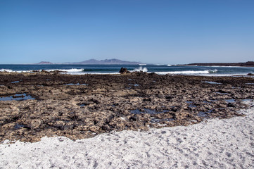 Shore of Fuerteventura with Lanzarote Island visible in the distance