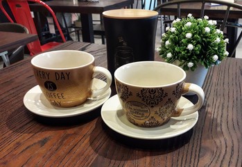 Two cups on a brown table, great for cafes, restaurants and more.