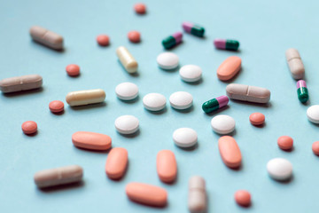 A lot of tablets and pills on blue background, medical treatment, medicine