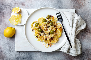 Italian pasta cacio e pepe, spaghetti mixed with grated cheese, green olives, lemon and raisins
